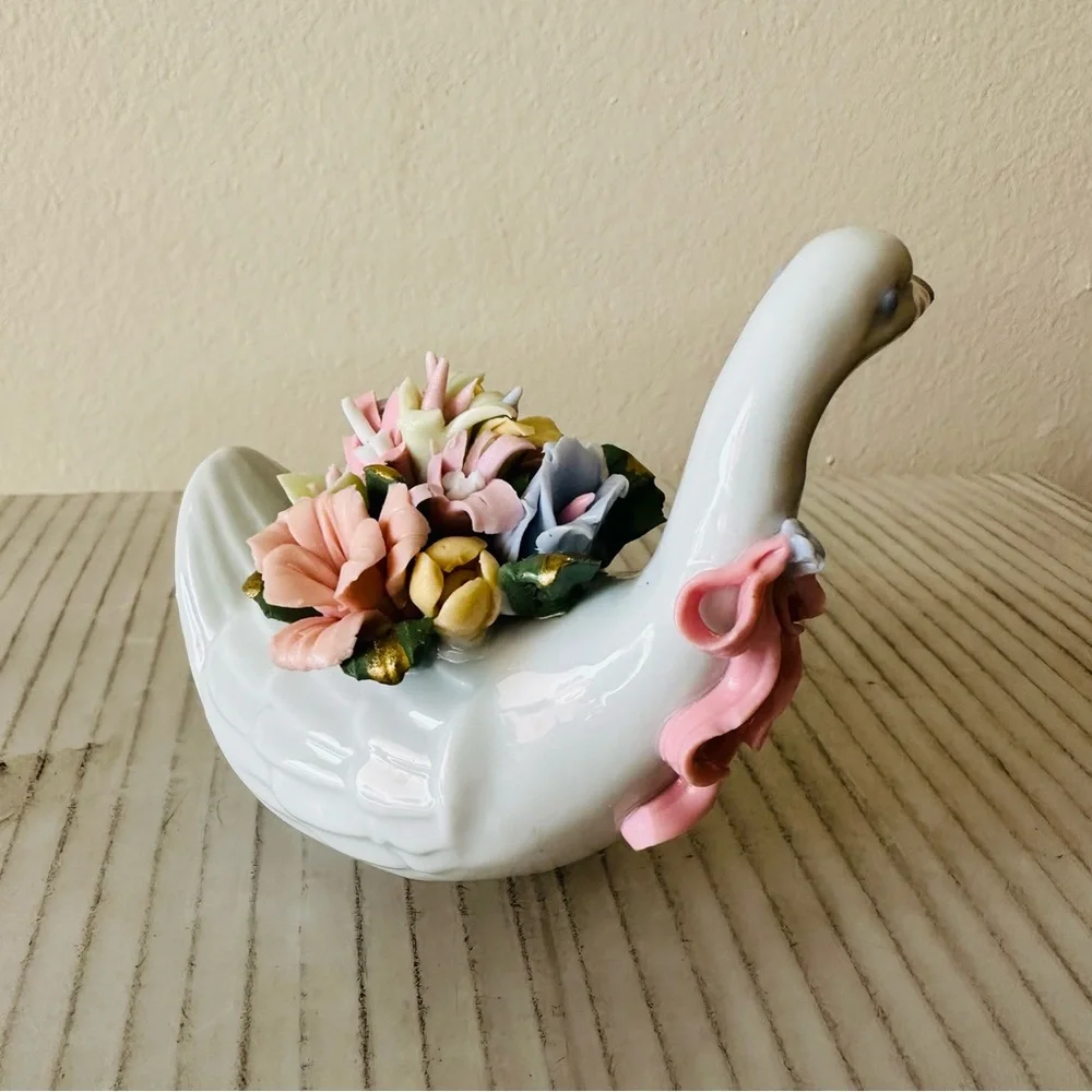 Beautiful little porcelain swan figurine with a back full of flowers!